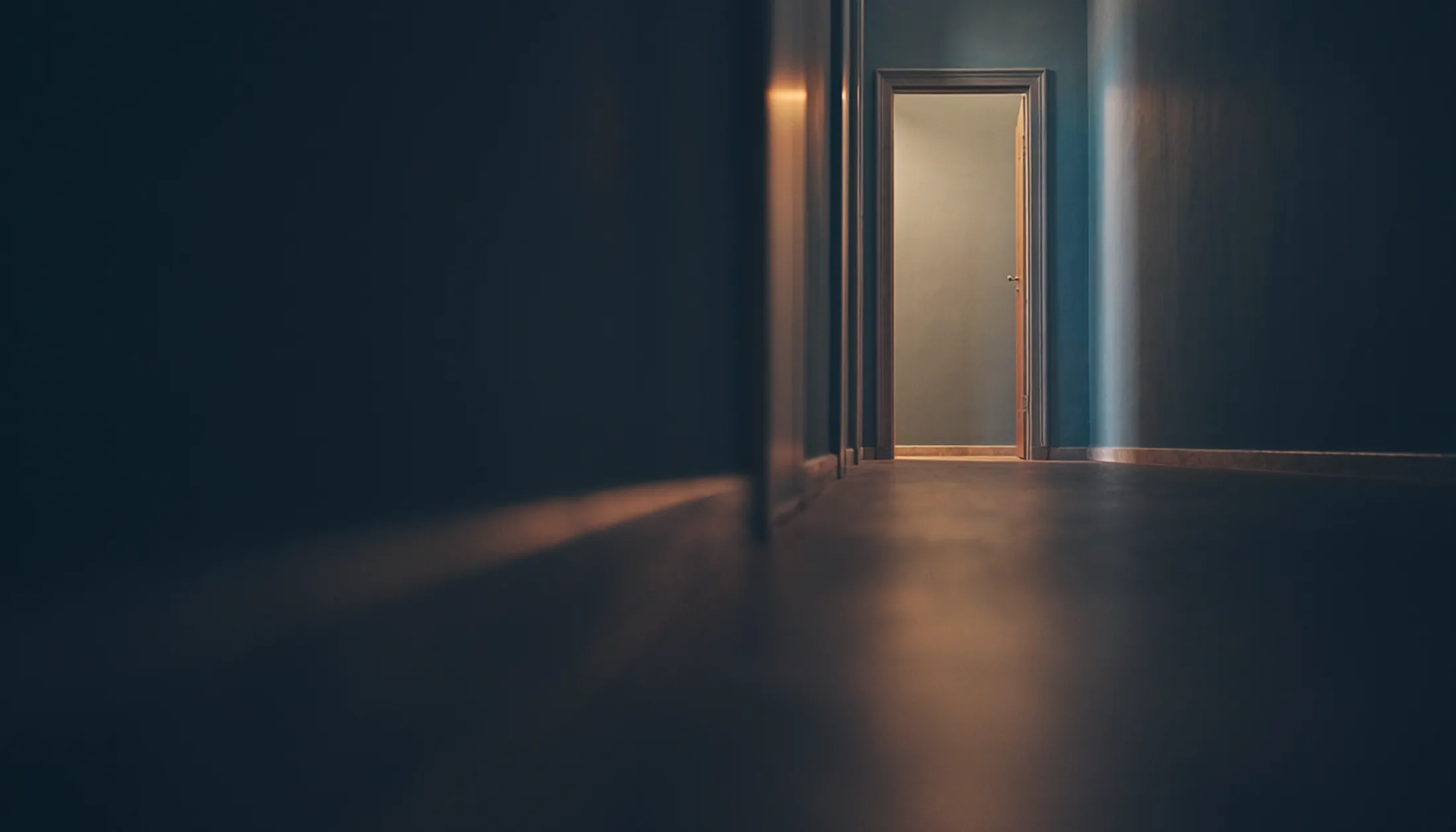 Dunkler Flur mit einer einzelnen offenen Tür am Ende, durch die warmes Licht fällt – Sinnbild für den ersten Schritt und den klaren Weg durch den Ablauf der Beratung bei Gabriele Perrer